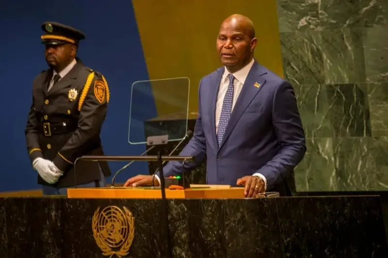 President Daniel Francisco Chapo speaking at the rostrum of the United Nations General Assembly Hall in New York, with a UN security officer standing behind him