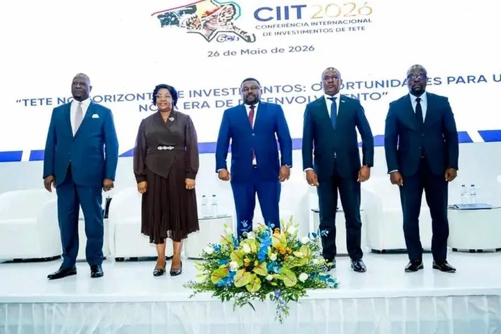 Cinco dirigentes de pé no palco do lançamento oficial da CIIT 2026, diante de um painel com o logótipo da Conferência, a data de 26 de Maio de 2026 e o lema do evento, com um arranjo de flores em primeiro plano
